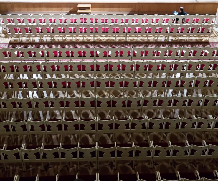 Foto auditório vazio no crepúsculo antes do concerto. espectador solitário na primeira fila. vista do topo
