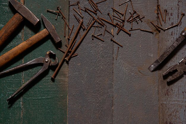 Auf alten Holzbohlen liegen Hammerzangen und rostige Nägel