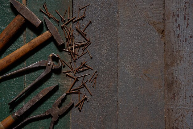 Auf alten Holzbohlen liegen Hammerzangen und rostige Nägel