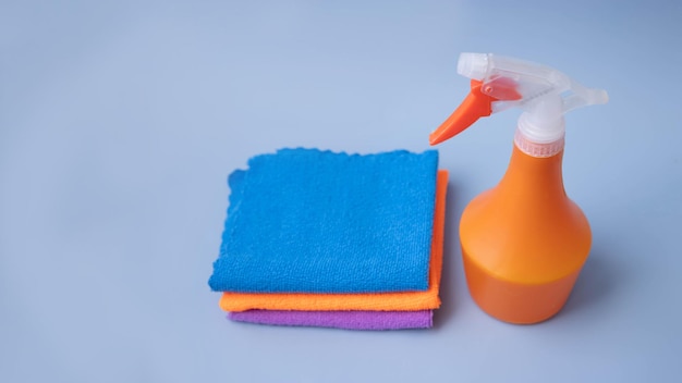 Foto auf blauem hintergrund ein orangefarbener pulevizer neben mikrofaser-reinigungstüchern von oben