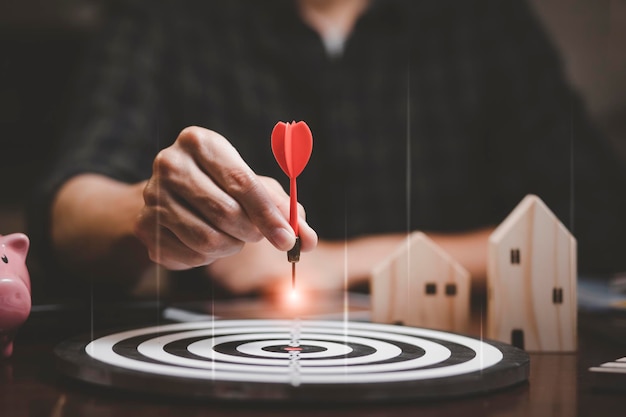 Auf das Geschäftskonzept abzielend, Businessman touch red arrow dart to the virtual Target Dartboard, Executive Marketing, Investment Goal und Target for Business Investment Concept, Mini Home.