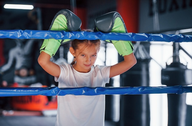 Auf dem Boxring. Junges kleines Mädchen in sportlicher Kleidung ist in der Turnhalle und hat einen Trainingstag.