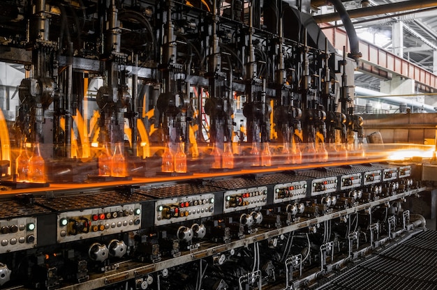 Auf dem Förderband werden Glasflaschen pasteurisiert mit Feuerproduktion von Glasflaschen und Getränken