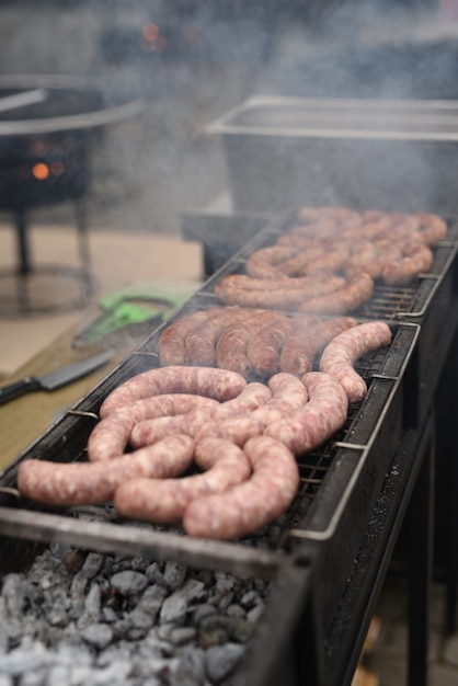 Auf dem Grill auf offenem Feuer Fleischwürste braten, alles in Rauch