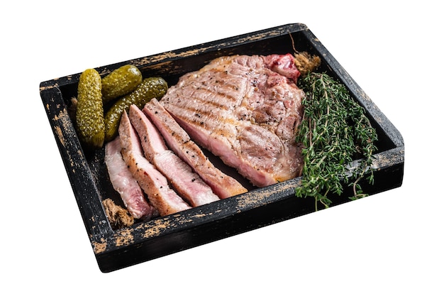 Auf dem Grill geröstete Schweinefleischsteaks aus Halsfleisch auf einem Holzplatt mit Kräutern, isoliert auf weißem Hintergrund