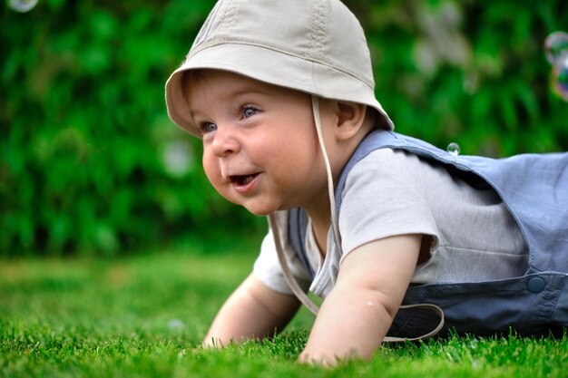 Auf dem Rasen sitzt ein fröhliches Baby