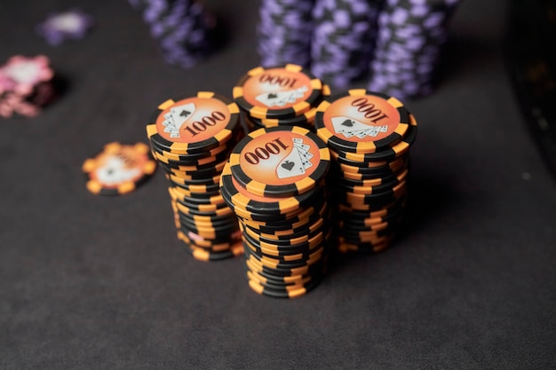 Auf dem Spieltisch liegen bunte Spielsteine der Pokerchips im Stapel. Hintergrund für Online-Casino.