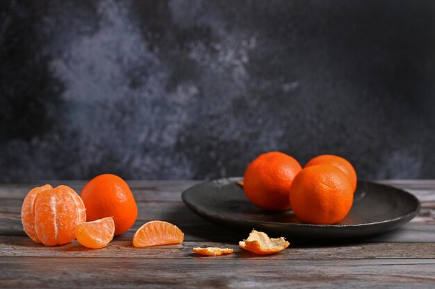 Auf dem Tisch liegen leuchtend orangefarbene Clementinen-Mandarinen