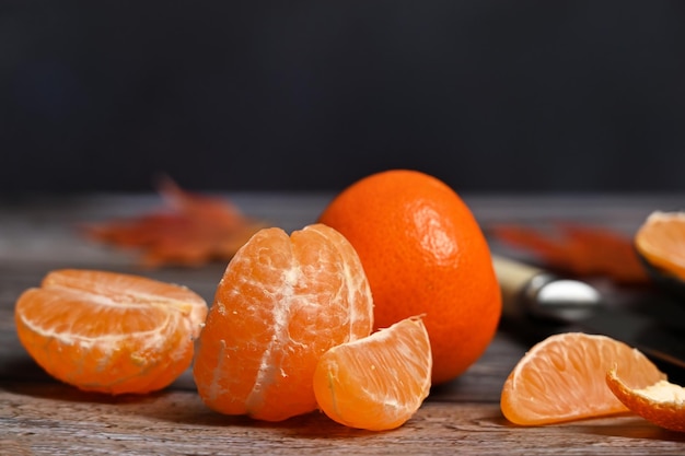 Auf dem Tisch liegen leuchtend orangefarbene Clementinen-Mandarinen