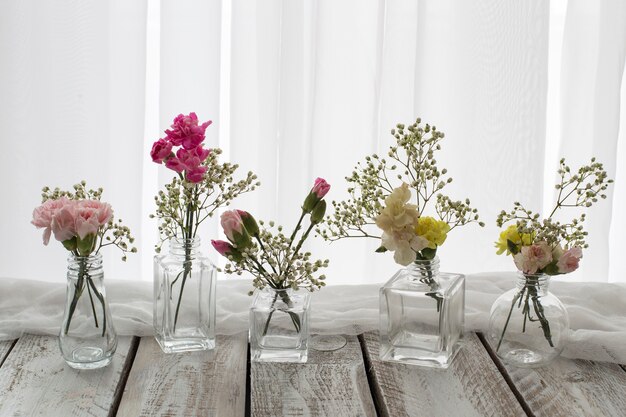 Foto auf dem tisch sind verschiedene vasen mit tortengrößen und formen mit blumen