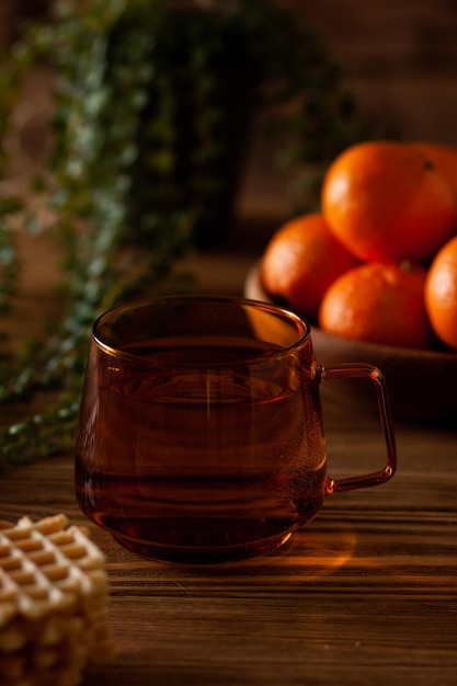 Auf dem Tisch steht eine Tasse Vitamintee mit Mandarinen