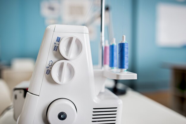 Auf dem weißen Tisch im Schneiderzimmer steht eine weiße elektrische Nähmaschine