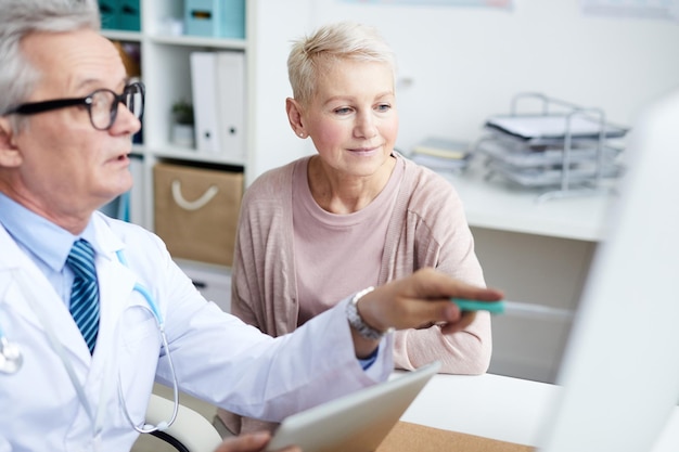 Auf den Monitor zeigen, während der Patient den CAT-Scan erklärt