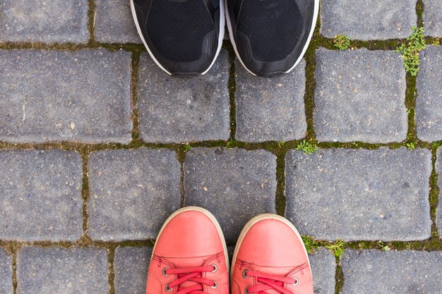 Auf den Pflastersteinen befinden sich zwei Paar Schuhe, Draufsicht