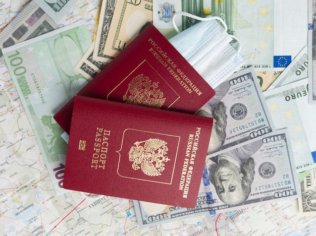 Auf der Karte befindet sich eine Nahaufnahme eines russischen Passes mit eingebetteten Dollarnoten. Das Konzept von Reisen und Erholung.. Draufsicht, flache Lage
