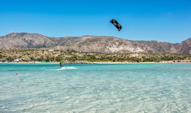 Auf der Oberfläche der Wasserrutschen Sportler Kitesurfer