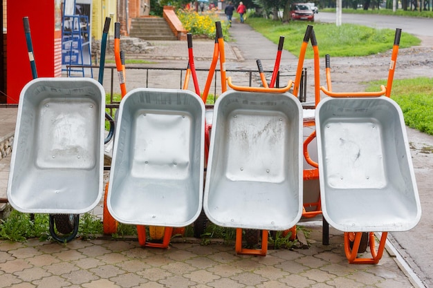 Auf der Straße in der Nähe des Baumarkts ist eine Reihe Gartenschubkarren ausgestellt