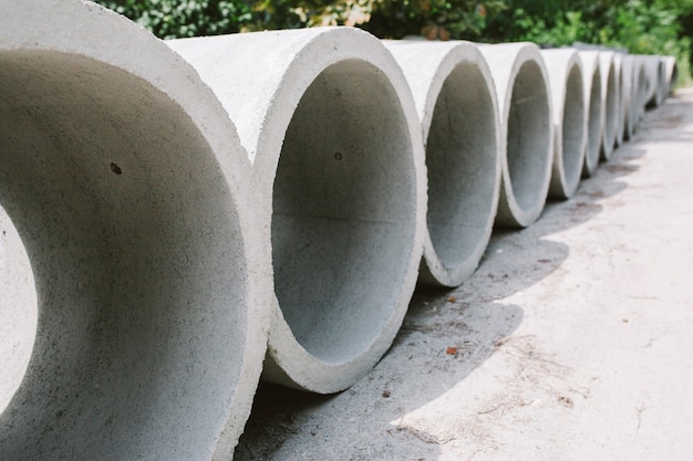 Auf der Straße liegen Betonringbrunnen mit unterschiedlichen Durchmessern und Grau