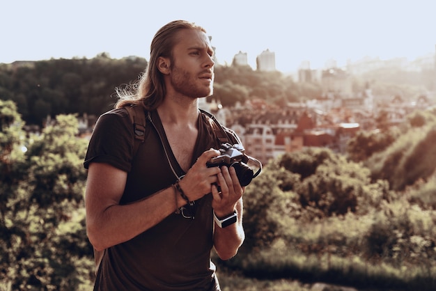 auf der Suche nach der perfekten Komposition. junger Mann in Freizeitkleidung fotografiert die Aussicht