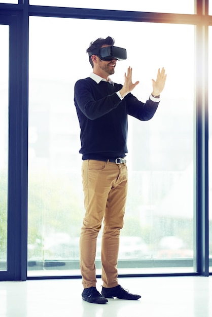 Auf der Suche nach einer Welt voller Möglichkeiten Aufnahme eines Geschäftsmanns mit einem VR-Headset in einem Büro
