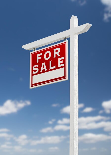 Auf einem blauen Himmel mit Wolken steht ein Schild mit dem Titel Verkauf von Immobilien