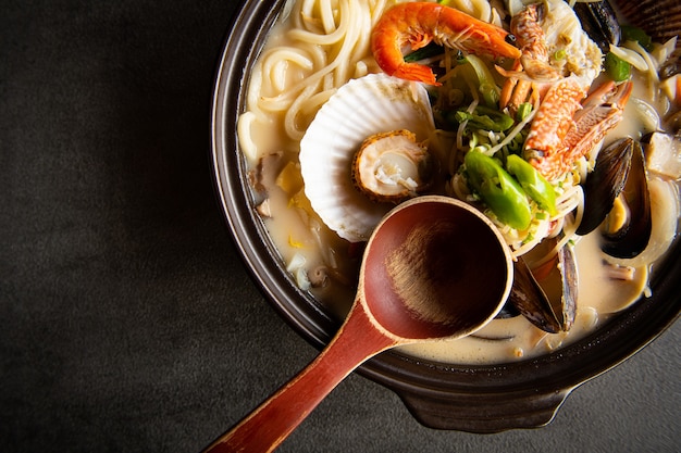 Auf einem gräulichen Tisch steht eine frische Gemüsesuppe