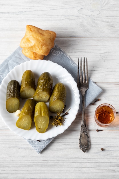 Auf einem Holztisch steht ein Glas Cognac, ein Snack aus einem Stück dunkler Schokolade und eine Flasche Alkohol