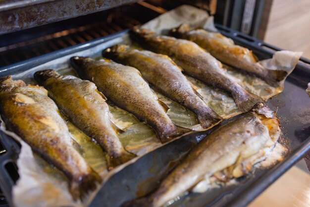 Auf einem metalltablett liegt viel gekochtes gebratenes gebratenes grillfleisch oder fisch vom grill oder ofen...