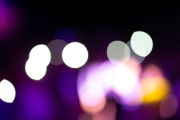 Auf einem schwarzen Hintergrund große Flecken von weißem und violettem Bokeh