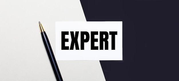 Auf einem Schwarzweißhintergrund liegen ein Stift und eine weiße Karte mit dem Text EXPERT