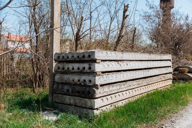 Auf einer Baustelle sind graue, alte Betonplatten übereinander gestapelt.