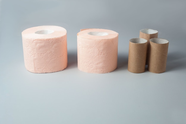 Auf grauem Grund stehen zwei Rollen pinkes Toilettenpapier und ein paar Ärmel davon.