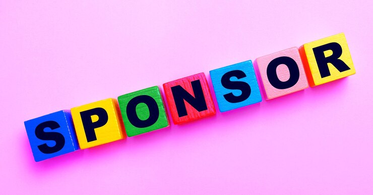 Auf hellrosa Hintergrund mehrfarbige Holzwürfel mit dem Text SPONSOR