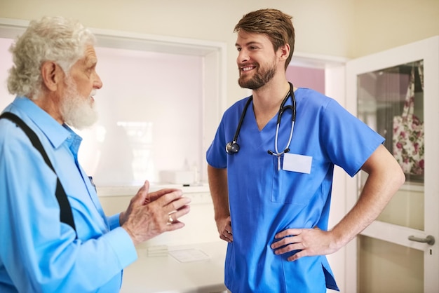 Auf jedes Symptom genau hören Aufnahme eines älteren Patienten, der sich mit seinem Arzt im Krankenhaus bespricht