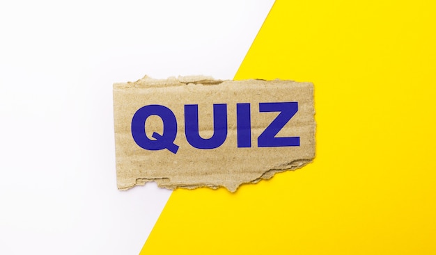 Auf weißem und gelbem Grund, brauner zerrissener Karton mit dem Text QUIZ