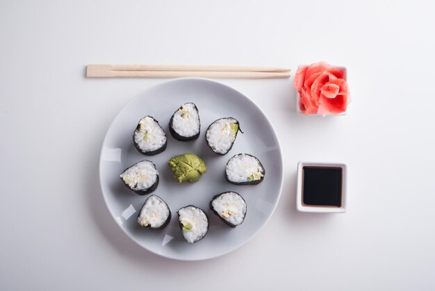 Aufbau von vegetarischen Sushi-Rollen aus Avocado und Gurke mit Ingwer-Wasabi und Sojasauce