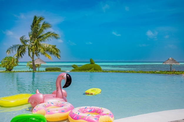 Aufblasbare Ringe, Matratze, die im Infinity-Pool schwimmt. Tropischer Erholungsort der Sommeransichtferien