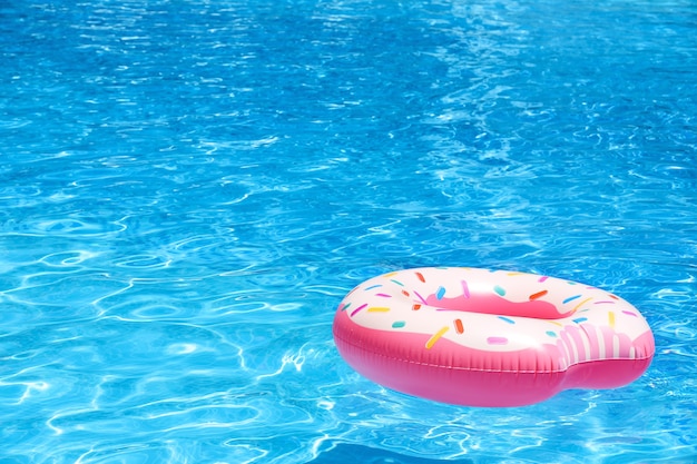 Aufblasbarer bunter Donut im blauen Schwimmbad