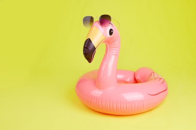 Aufblasbarer Flamingo mit Sonnenbrille auf gelbem Hintergrund, Strandspielzeug