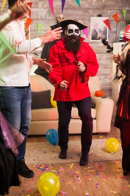 Foto aufgeregt wie ein pirat verkleideter mann auf einer halloween-party mit seinen freunden.