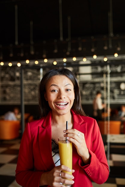 Aufgeregte Dame, die alkoholischen Cocktail trinkt