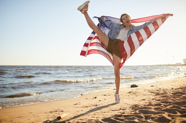 Foto aufgeregte flexible frau mit us-flagge