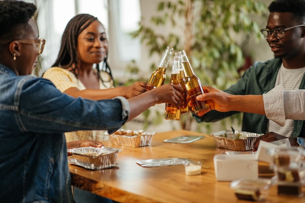 Aufgeregte Freunde, die mit Biergläsern anstoßen