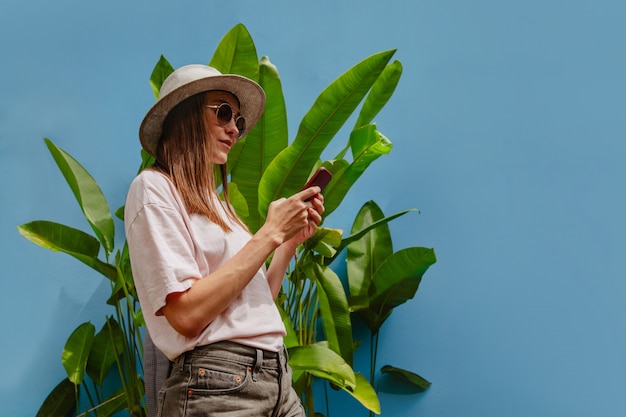 Aufgeregte junge Frau im Urlaub verwendet Smartphone