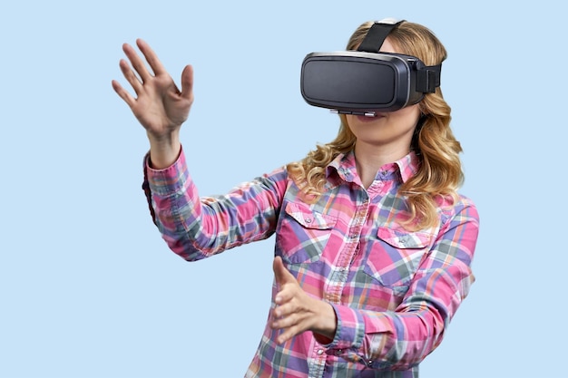 Aufgeregte junge Frau mit Virtual-Reality-Brille auf Farbhintergrundtechnologie der neuen Generation und