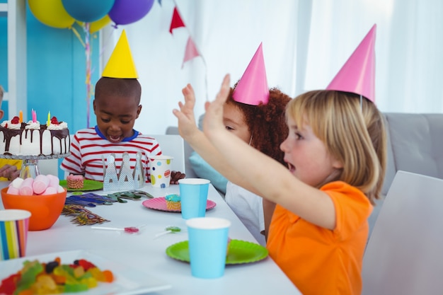 Aufgeregte Kinder, die eine Geburtstagsfeier genießen