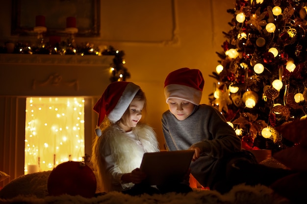 Aufgeregte Kinder nahe Weihnachtsbaum