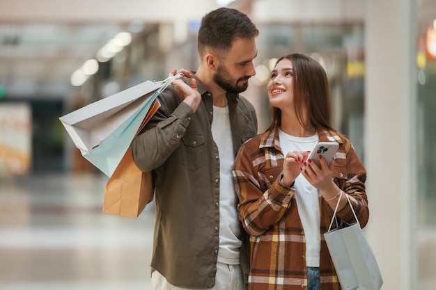 Aufgeregte Leute mit Smartphones Ein junges Paar ist zusammen im Supermarkt