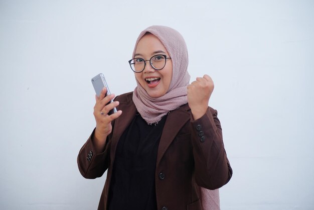 Aufgeregte muslimische Frau, während sie das Telefon in der Hand hält