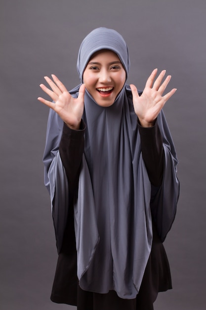 Aufgeregte, überraschte, fröhliche, lachende muslimische Frau mit Hijab oder Kopftuch